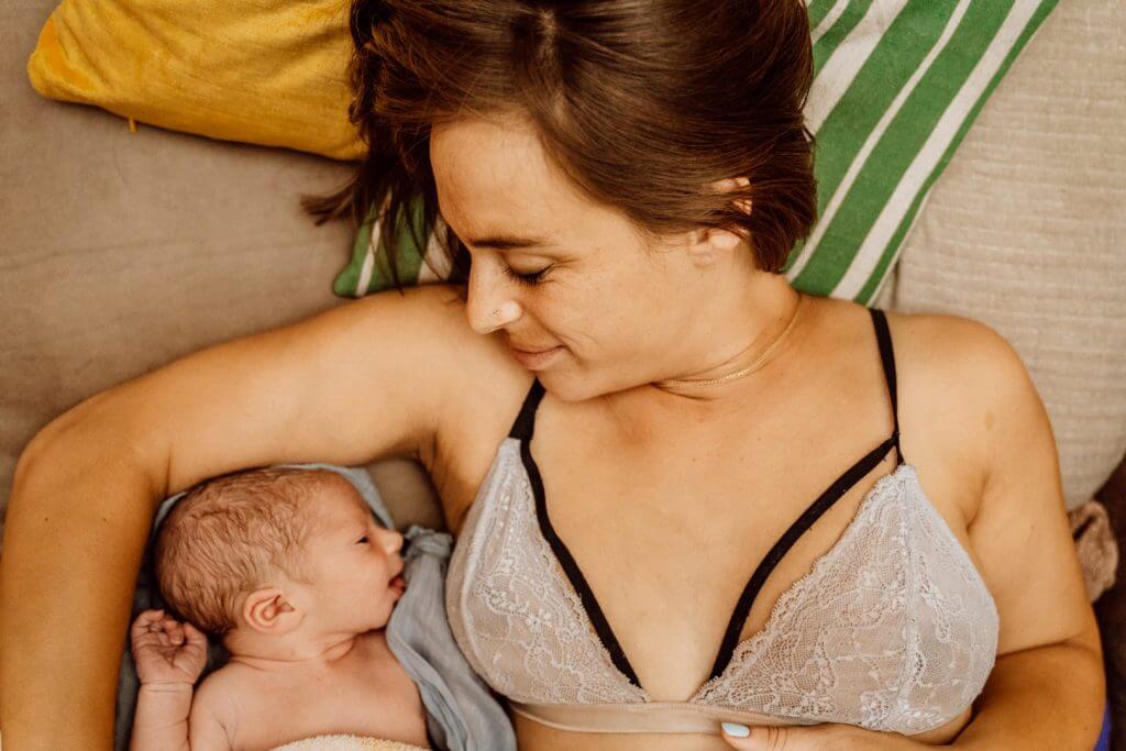 Mama kuschelt mit Baby nach Hausgeburt