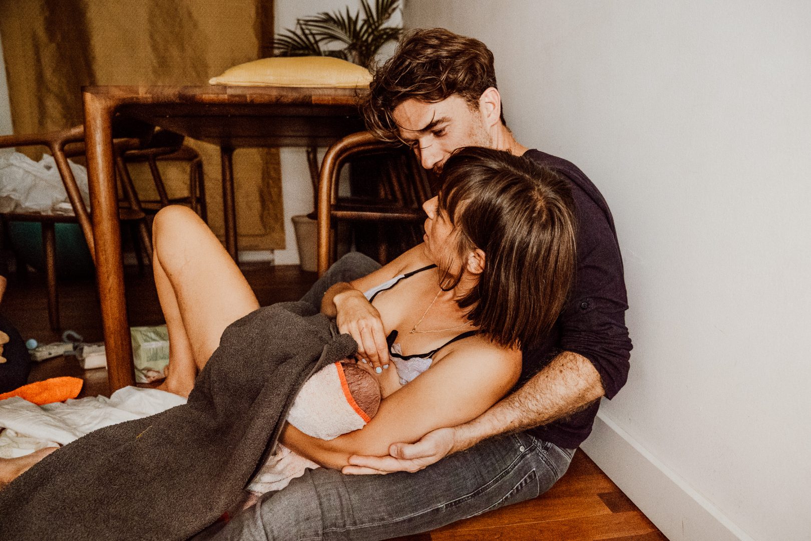 Vater hält Mutter nach Geburt im Arm