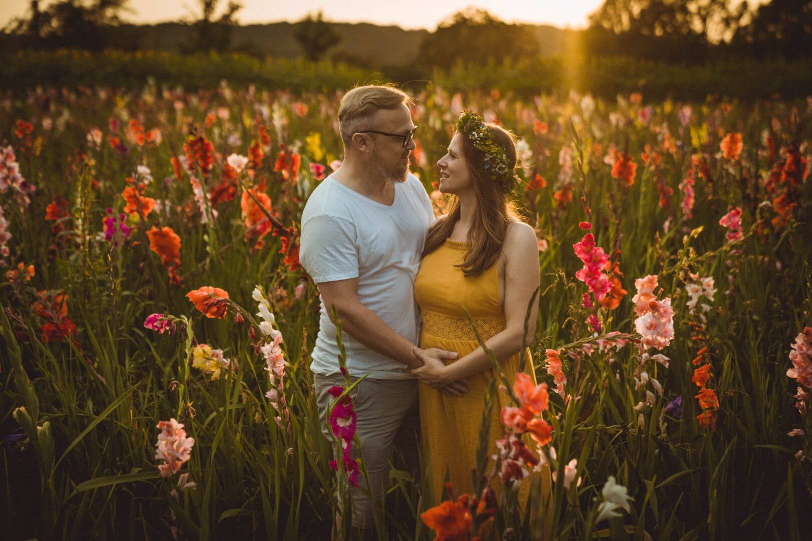 Paar steht in Gladiolenfeld im Sonnenuntergang