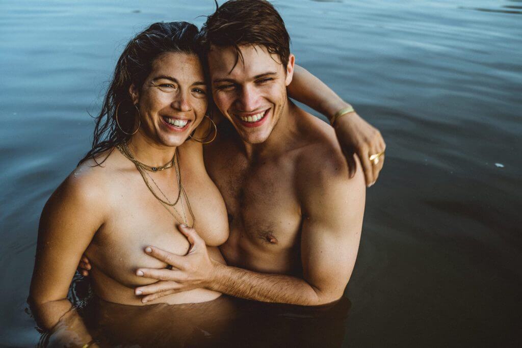 Paar steht im Wasser und lächeln in die Kamera