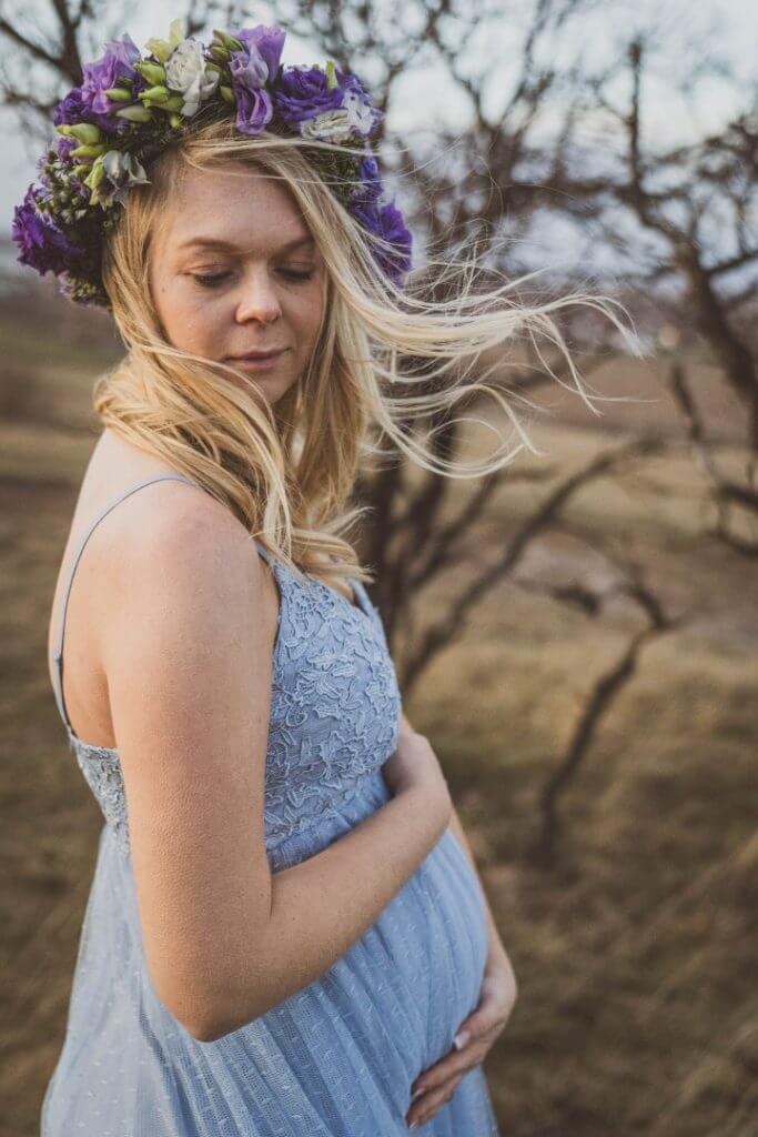 Schwangere lässt blonde Haare im Wind wehen