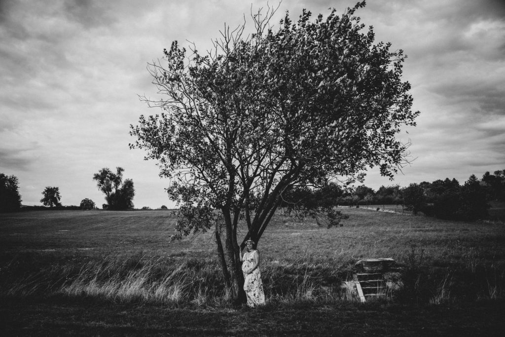 Schwangere steht unter Baum