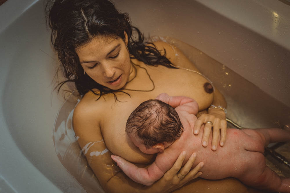 Mutter badet mit Neugeborenem