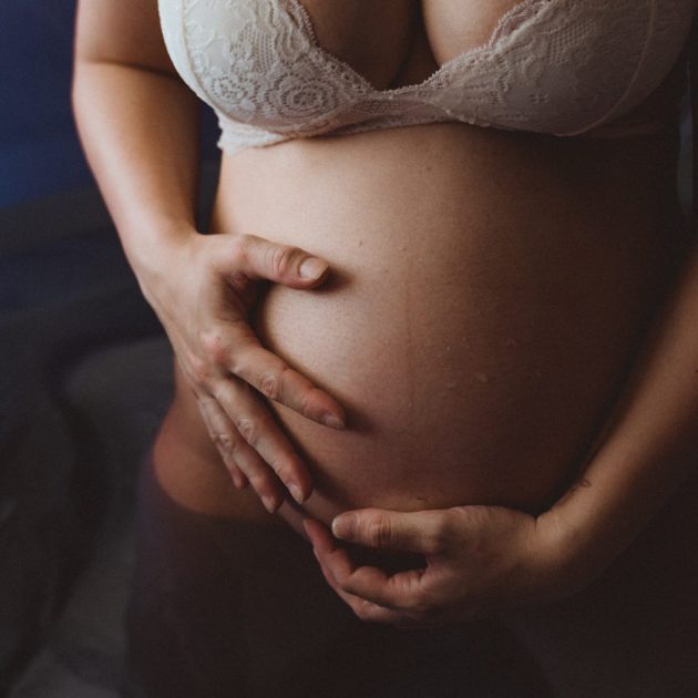 Schwangere hält Bauch in Geburtspool