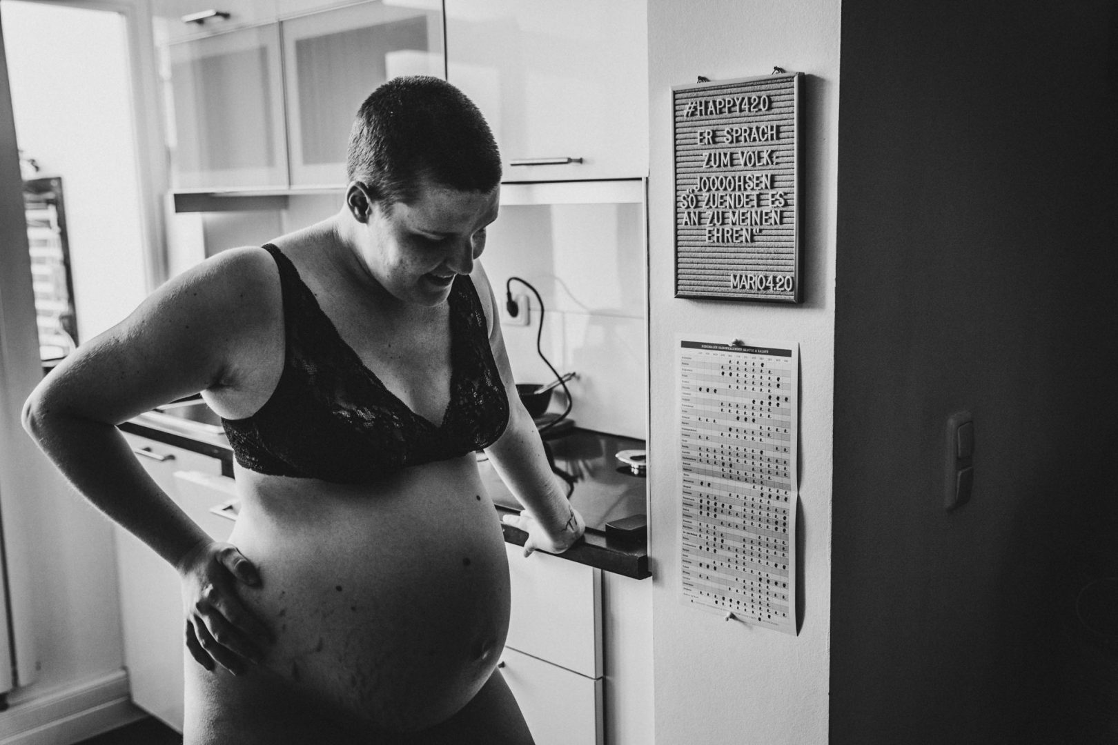 Schwangere steht während Hausgeburt in der Küche