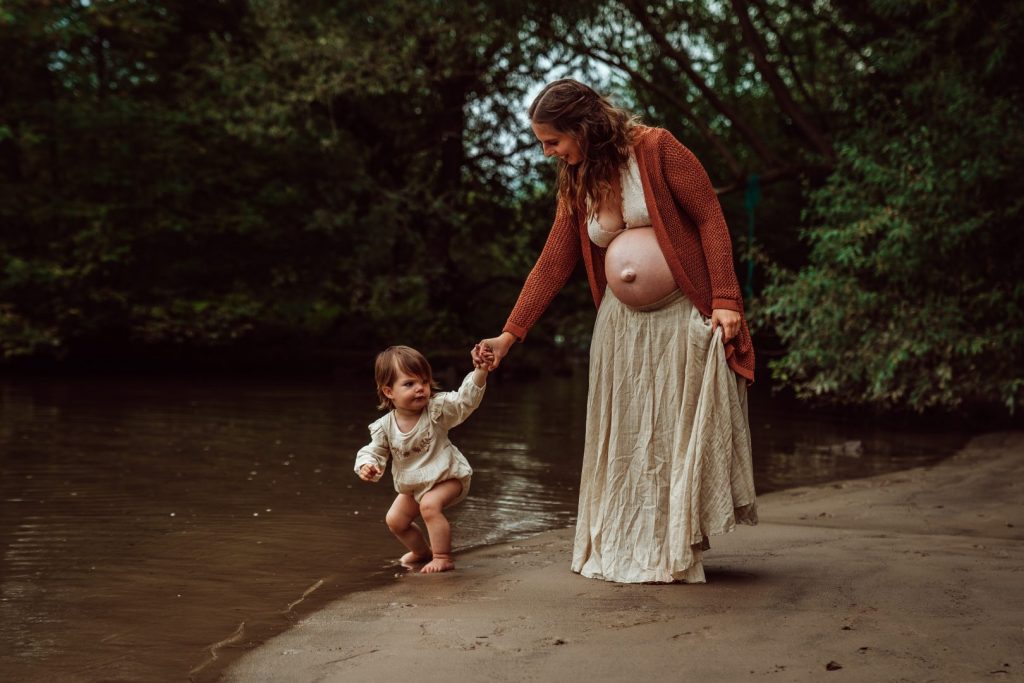Schwangere hält Kleinkind an der Hand