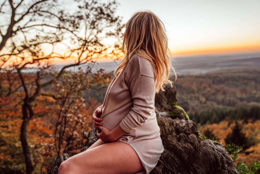 Schwangere blickt auf Fels in Fernre