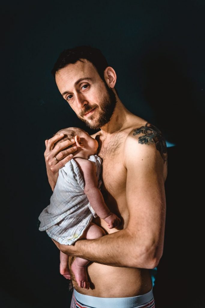 Vater hält Baby auf nackter