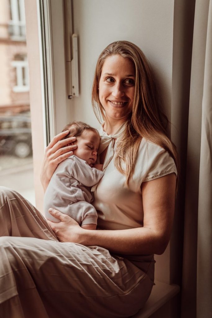 Mama hält Neugeborenes im Arm
