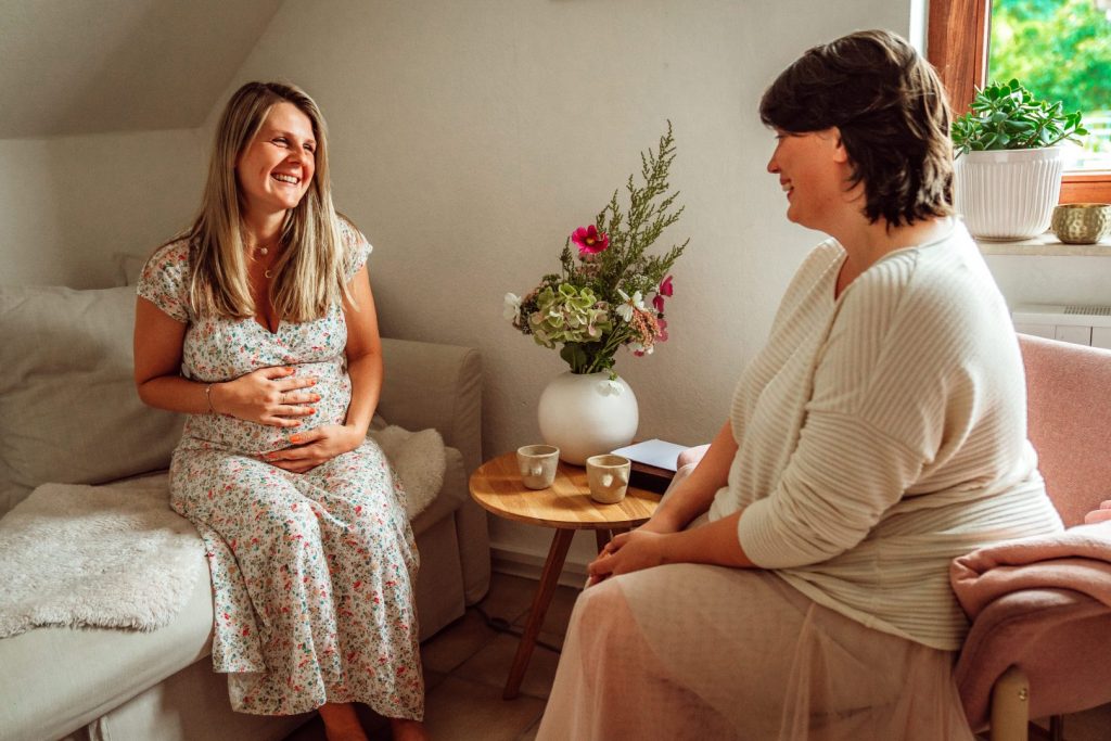 Frauen sitzen und unterhalten sich mit einer Tasse Tee