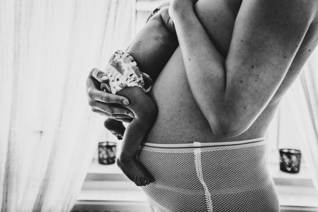 Mama legt Neugeborenes auf ihren Bauch