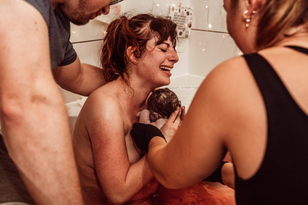 Mama weint nach Geburt ihres Babys