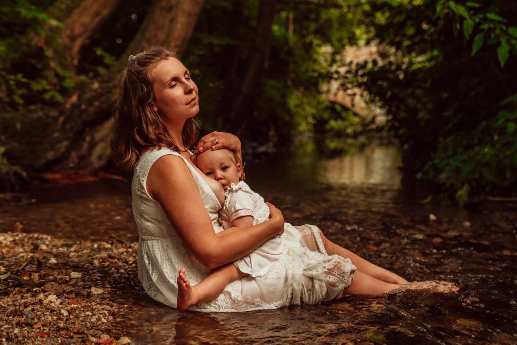 Mama stillt Kind in Bach