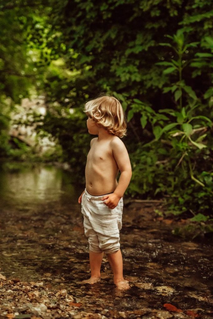Junge steht an Bach